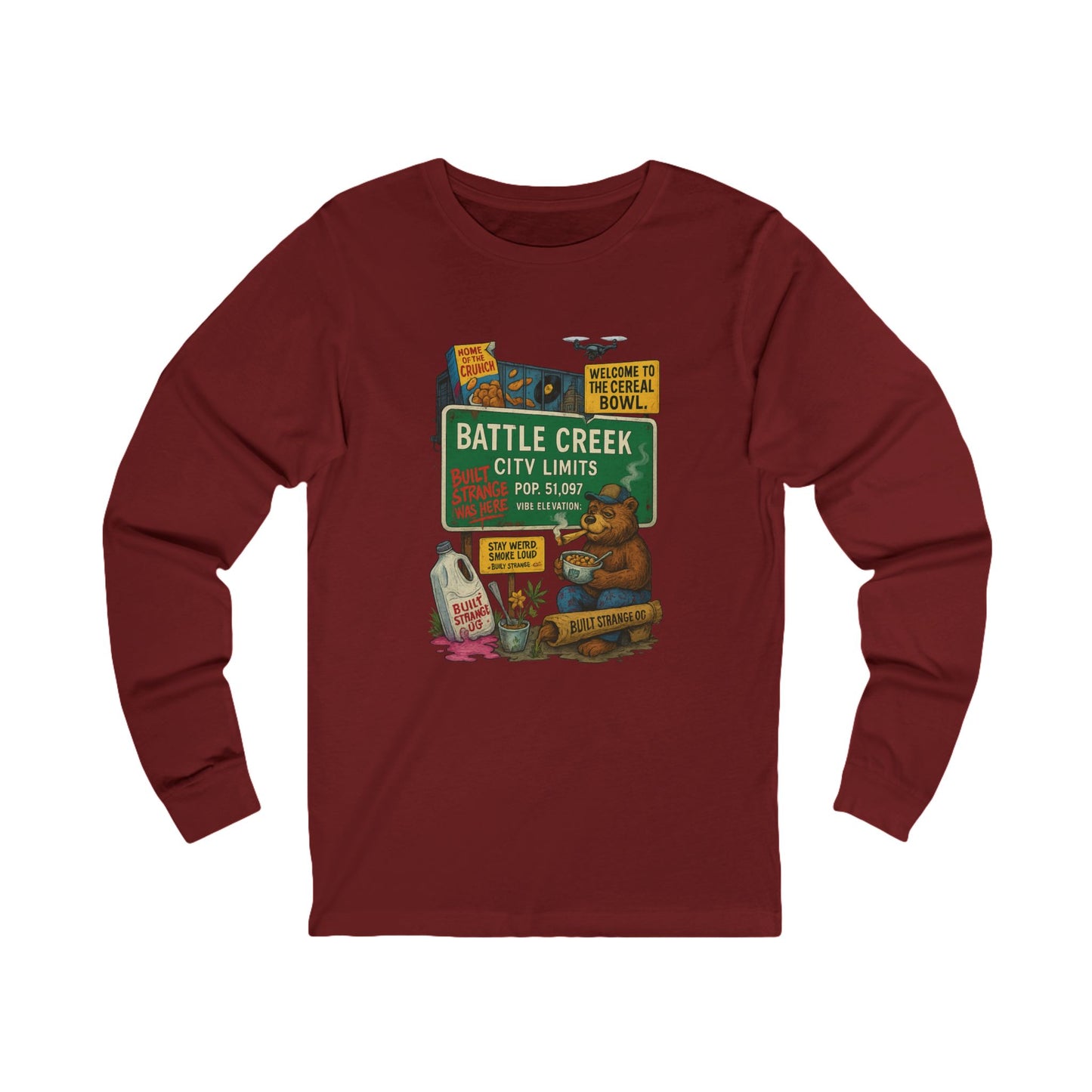 Pour up the crunch and light one up — the Battle Creek “Built Strange Was Here” long sleeve tee celebrates the cereal capital in true Built Strange fashion. Featuring the iconic bear kicking back with a bowl and a smoke, this design mixes nostalgia, humor, and that unmistakable Midwest chill.

Premium jersey long sleeve tee

Soft, breathable cotton with a relaxed fit

Full-color front print with vivid detail

Perfect for laid-back days or layered looks

Designed by Built Strange Apparel
