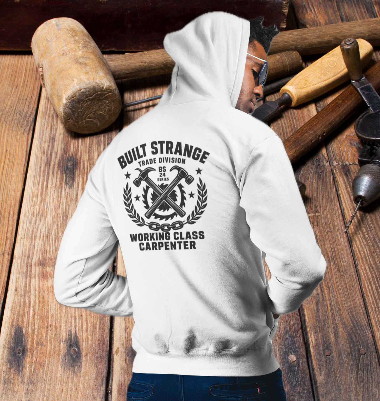 Step onto the jobsite or the street in true carpenter pride.
This Built Strange hoodie features:

Front: Bold Built Strange Trades crest logo on the chest.

Back: Full “Working Class Carpenter” design – crossed hammers, saw blade, laurel wreath, and chain badge, built tough for the BS 24 Series.

Midweight fleece for all-season comfort.

Streetwear edge + tradewear grit = everyday armor.

Made for union brothers, blue-collar grinders, and anyone repping the trades with pride.