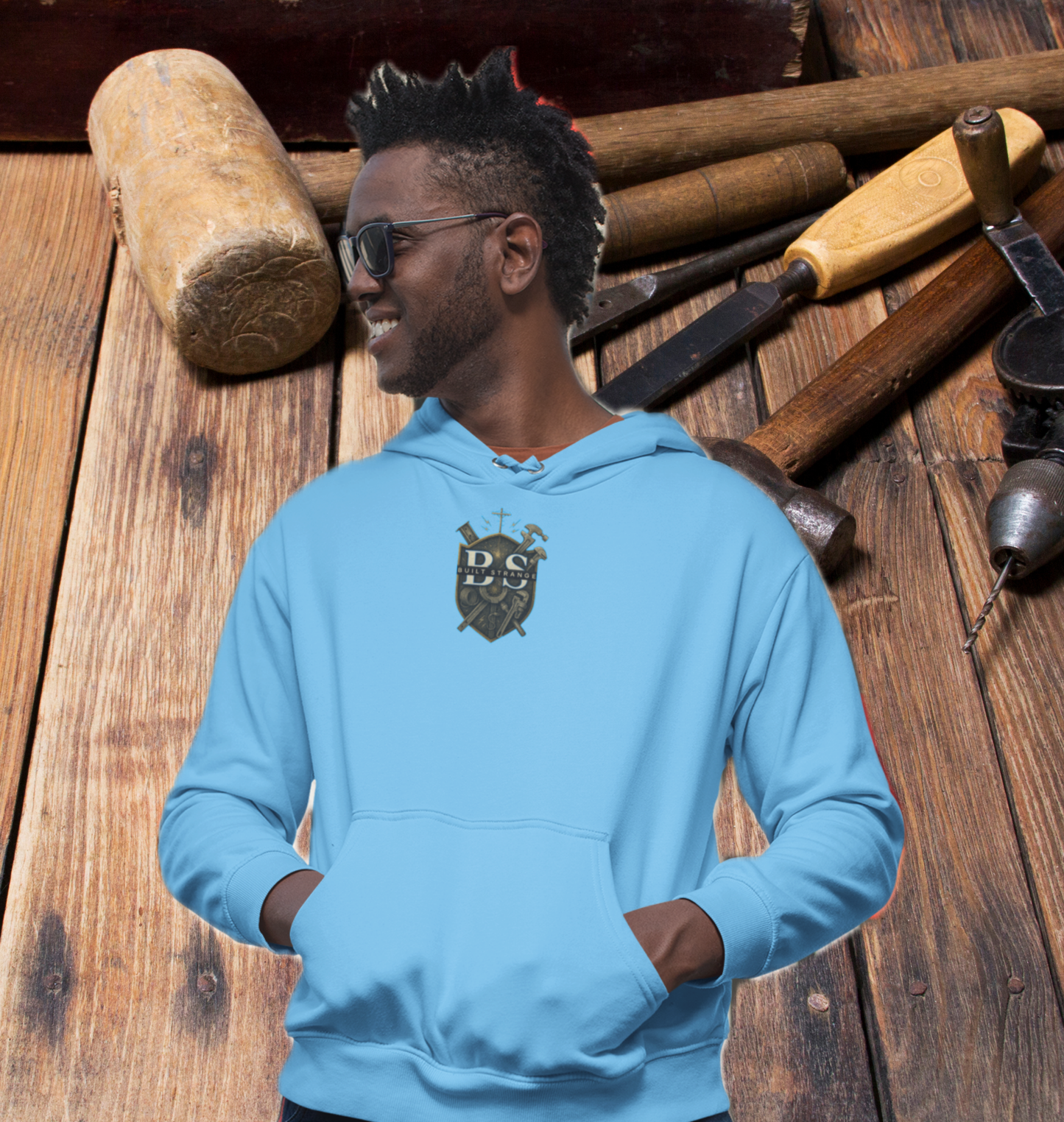 Step onto the jobsite or the street in true carpenter pride.
This Built Strange hoodie features:

Front: Bold Built Strange Trades crest logo on the chest.

Back: Full “Working Class Carpenter” design – crossed hammers, saw blade, laurel wreath, and chain badge, built tough for the BS 24 Series.

Midweight fleece for all-season comfort.

Streetwear edge + tradewear grit = everyday armor.

Made for union brothers, blue-collar grinders, and anyone repping the trades with pride.