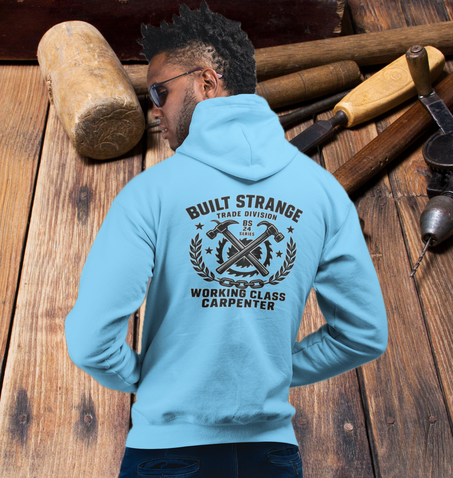 Step onto the jobsite or the street in true carpenter pride.
This Built Strange hoodie features:

Front: Bold Built Strange Trades crest logo on the chest.

Back: Full “Working Class Carpenter” design – crossed hammers, saw blade, laurel wreath, and chain badge, built tough for the BS 24 Series.

Midweight fleece for all-season comfort.

Streetwear edge + tradewear grit = everyday armor.

Made for union brothers, blue-collar grinders, and anyone repping the trades with pride.
